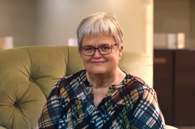 A smiling woman seated in a comfortable chair