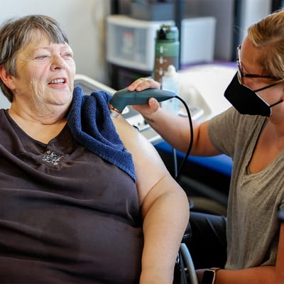 Resident receiving therapy treatment from staff member