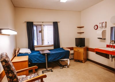 Interior view of a resident room with bed and furnishings