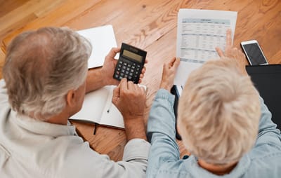 Two seniors engaged in a budgeting activity