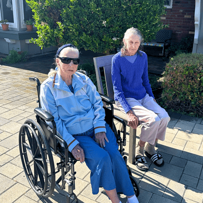 Two residents enjoying time outdoors in wheelchairs