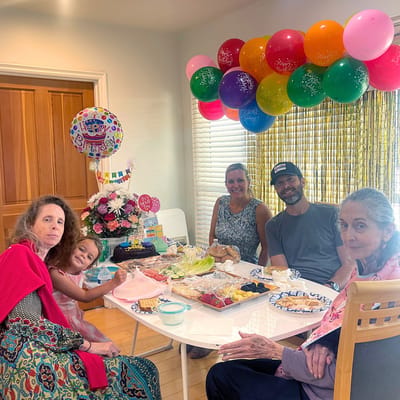 Residents and staff celebrating with food and balloons