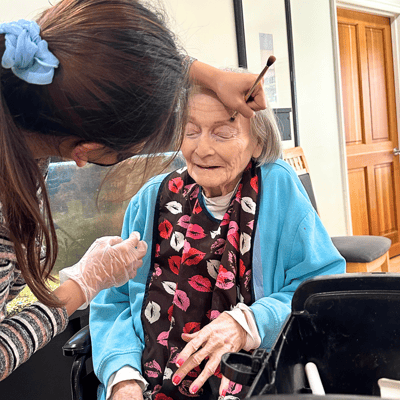 Staff providing makeup services to a resident