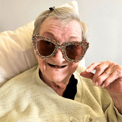 A smiling resident wearing oversized decorative sunglasses