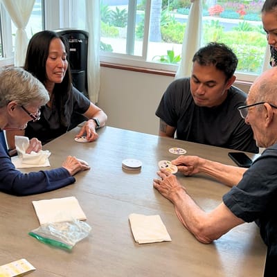 Residents and staff engaged in a card game