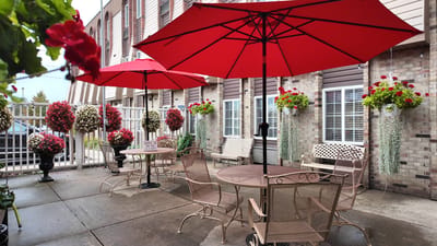 Outdoor seating area with red umbrellas and flowers