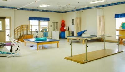 Interior activity room with therapy equipment and exercise mats