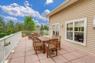 Outdoor patio area with wooden furniture and greenery