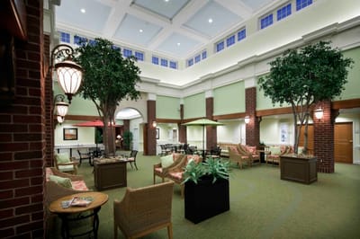 Common area with seating and plants in a well-lit lobby