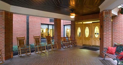 Covered entrance with rocking chairs and foyer area