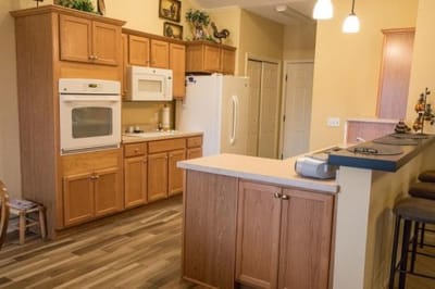 Bright kitchen area with wooden cabinets and appliances