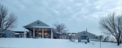 Exterior view of a senior living facility in snow