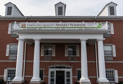 Front entrance of a nursing home facility with award banner
