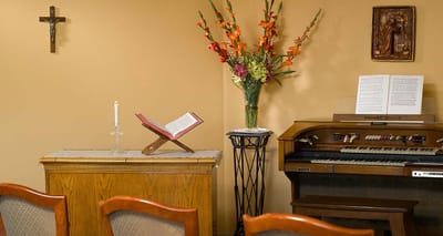 A serene interior space with a music organ and flowers