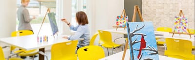 Residents participating in an art class in a bright activity room