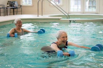Residents exercising in a warm pool during therapy