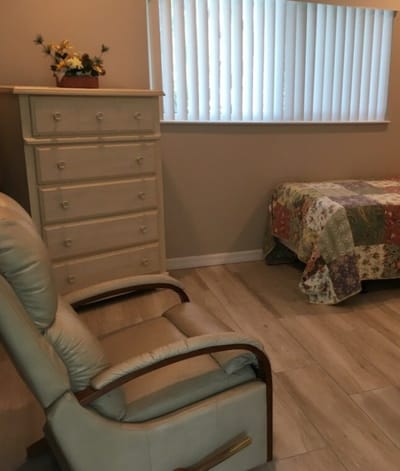 Cozy interior of a resident's room with a chair and dresser