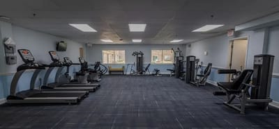 Empty fitness room with exercise equipment and light blue walls