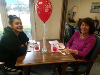 Residents celebrating a birthday with cake and drinks