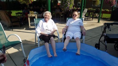 Two residents enjoying a foot soak in an outdoor area