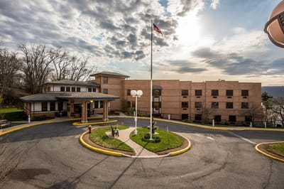 Adira At Riverside Rehabilitation & Nursing, Nursing Home in Yonkers, NY — Circular driveway with flagpole and building in background
