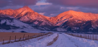 Mountain landscape at sunset with snow and fields