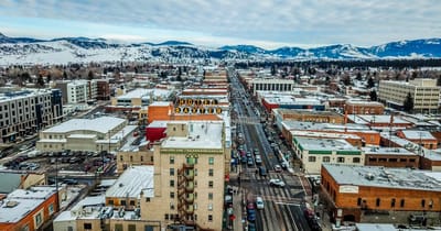 Aerial view of a snowy town with buildings and mountains
