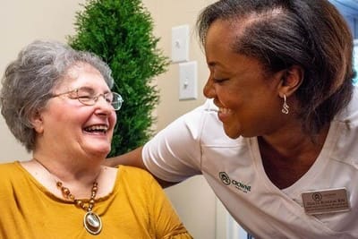 Crowne Health Care of Fort Payne, Nursing Home in Fort Payne, AL — Resident and caregiver sharing a joyful conversation
