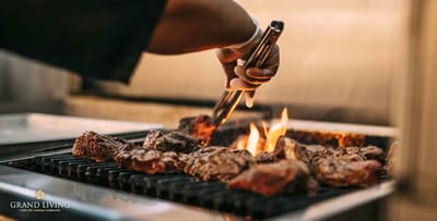 A staff member grilling food outdoors at an event