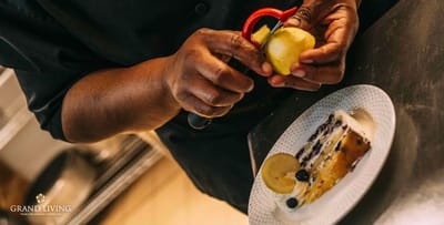 A chef peeling an apple next to a dessert plate