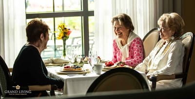 Three residents enjoying a meal together in a dining area