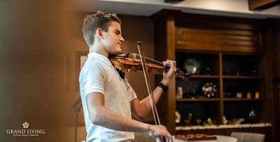 A young musician playing the violin in a warm interior setting