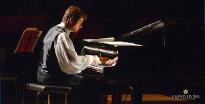 A musician performing at a piano on stage