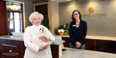 Resident holding a dog at a reception area