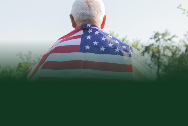 Senior person wrapped in an American flag outdoors