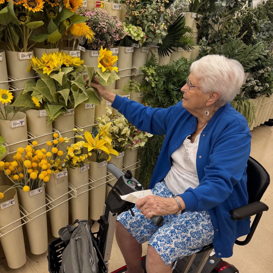 A resident selecting flowers in a store