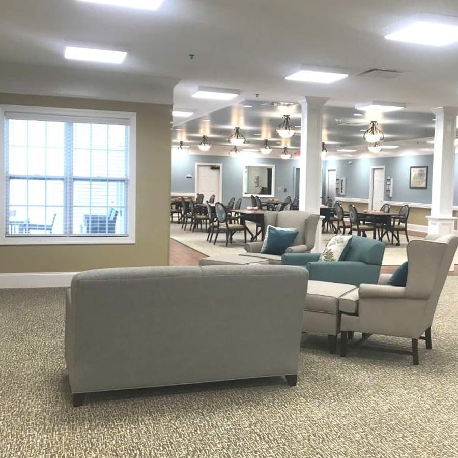 Bright activity room with seating and dining areas