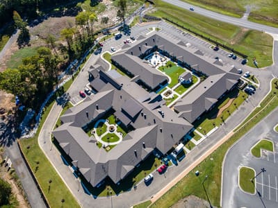 Aerial view of a senior living facility with landscaped grounds