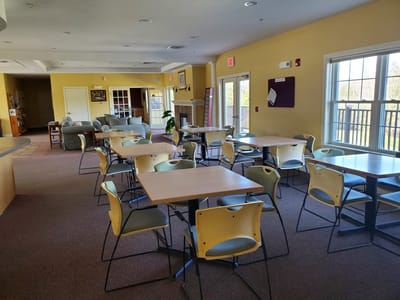 Common area with tables and chairs in a bright room