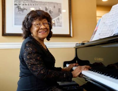 Resident playing piano in a common area