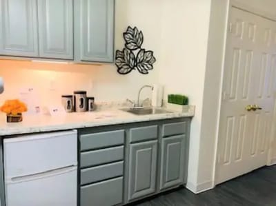 A kitchen area with gray cabinets and countertop