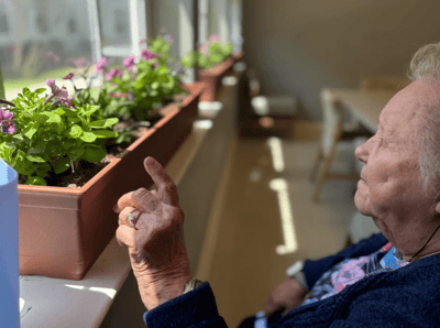 Resident enjoying flowers by the window