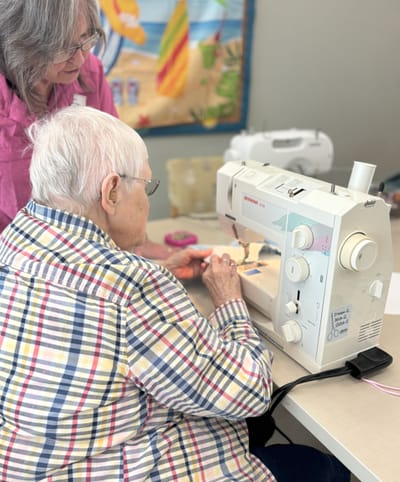 Residents enjoying a sewing activity at a table