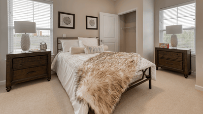 Well-decorated private resident room with a bed and furniture