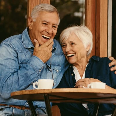 Elderly couple enjoying coffee on a patio