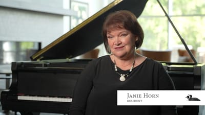 A resident posed near a grand piano in a common area
