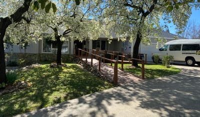Exterior view of senior care facility with blossoming trees