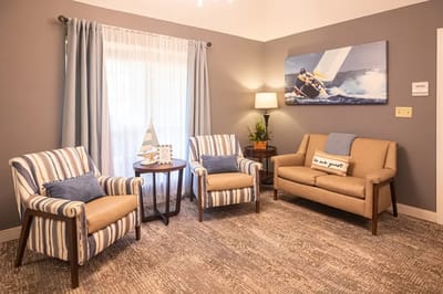 Cozy sitting area with striped chairs and a painting