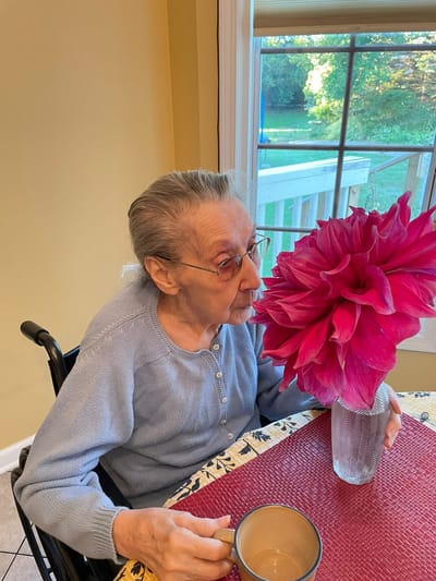 Resident enjoying a flower in the dining area