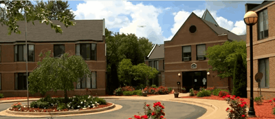 Exterior view of Holt Heritage Village with blooming flowers and greenery
